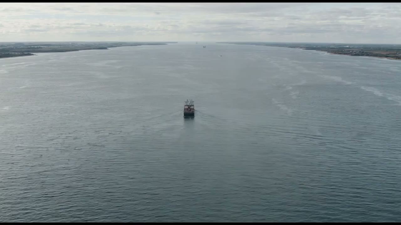 Anonymous container vessel small on a grey shipping corridor. No funnel marks.