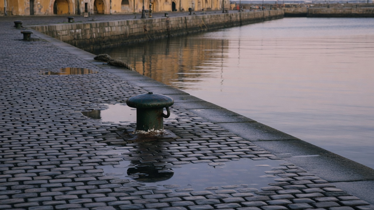 Quiet European harbour quay in late light. No identifiable ships.