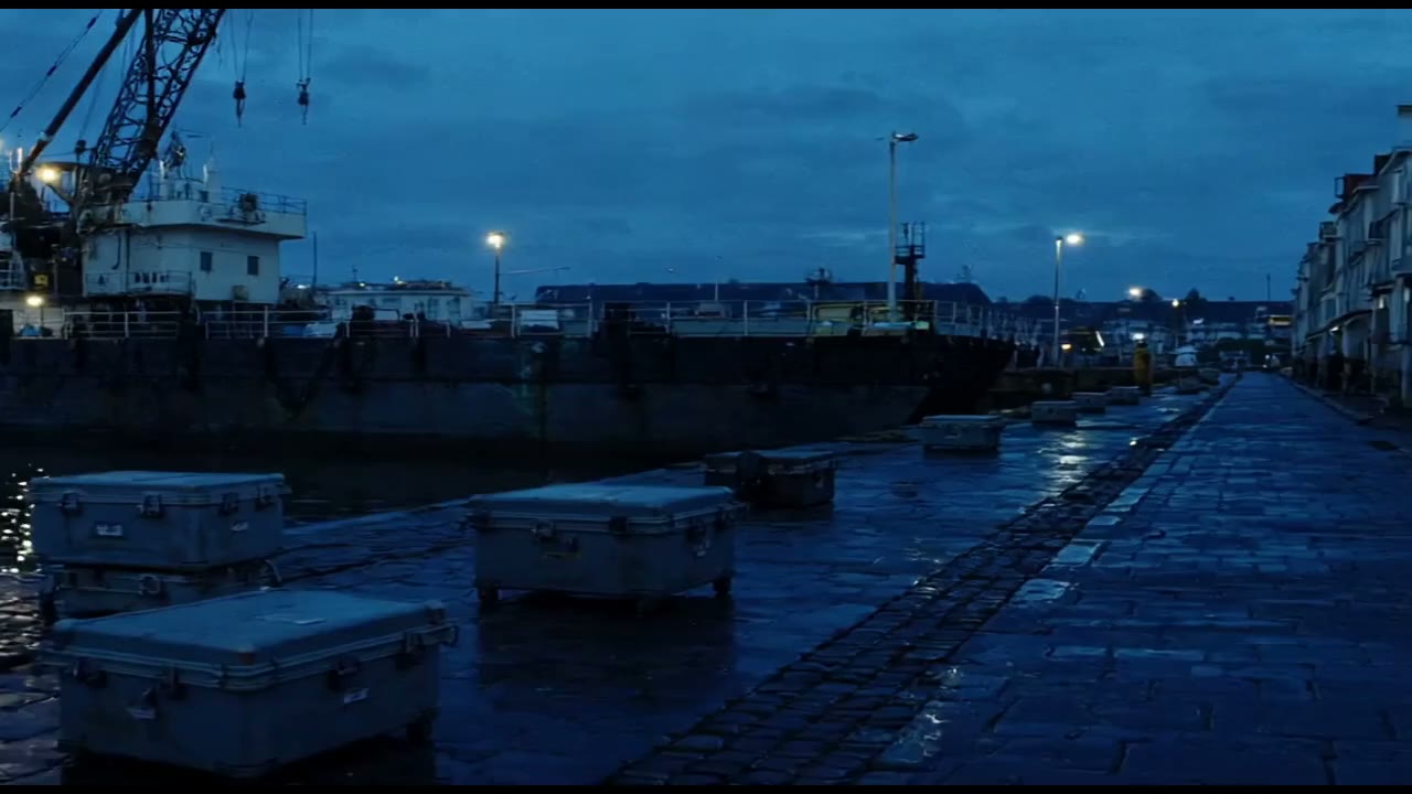 Quiet European harbour quay in late light. Anonymous hull, closed cases.